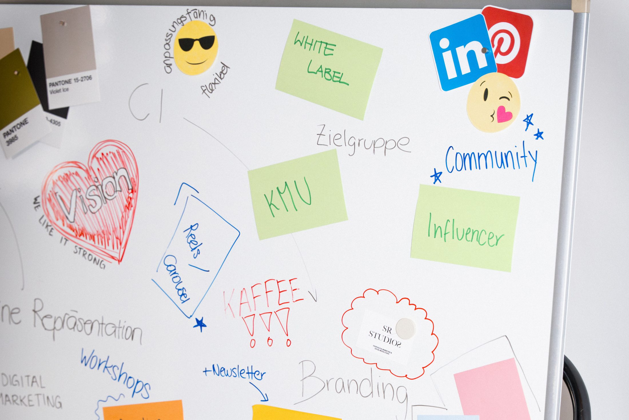 Whiteboard einer Digital Marketing Agentur mit Notizen zu Social Media Strategie und Branding. Auf dem Board kleben das LinkedIn Logo sowie Haftnotizen zu Zielgruppe und KMU Marketing. SR-STUDIOS. | SR-STUDIOS