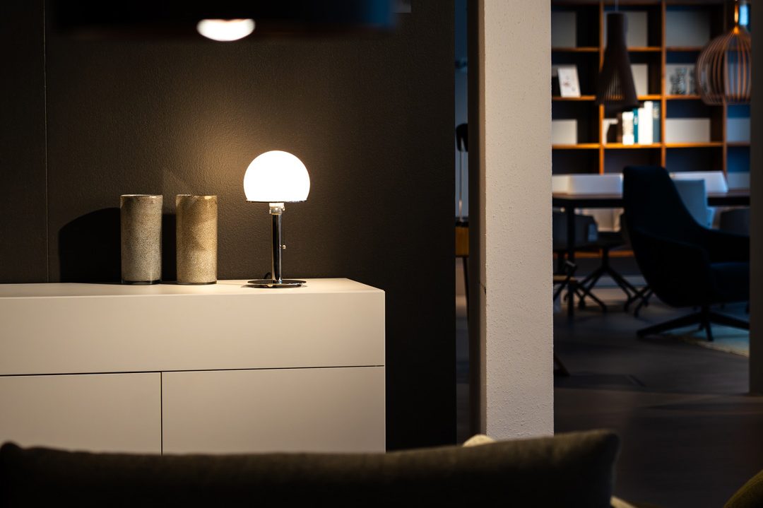 Stilvolle Kommode mit Tischleuchte in atmosphärischer Abendbeleuchtung; Interior Design mit Fokus auf Lichtkonzept, Wohnästhetik und hochwertige Möbelmarke; pure von vifian. | SR-STUDIOS