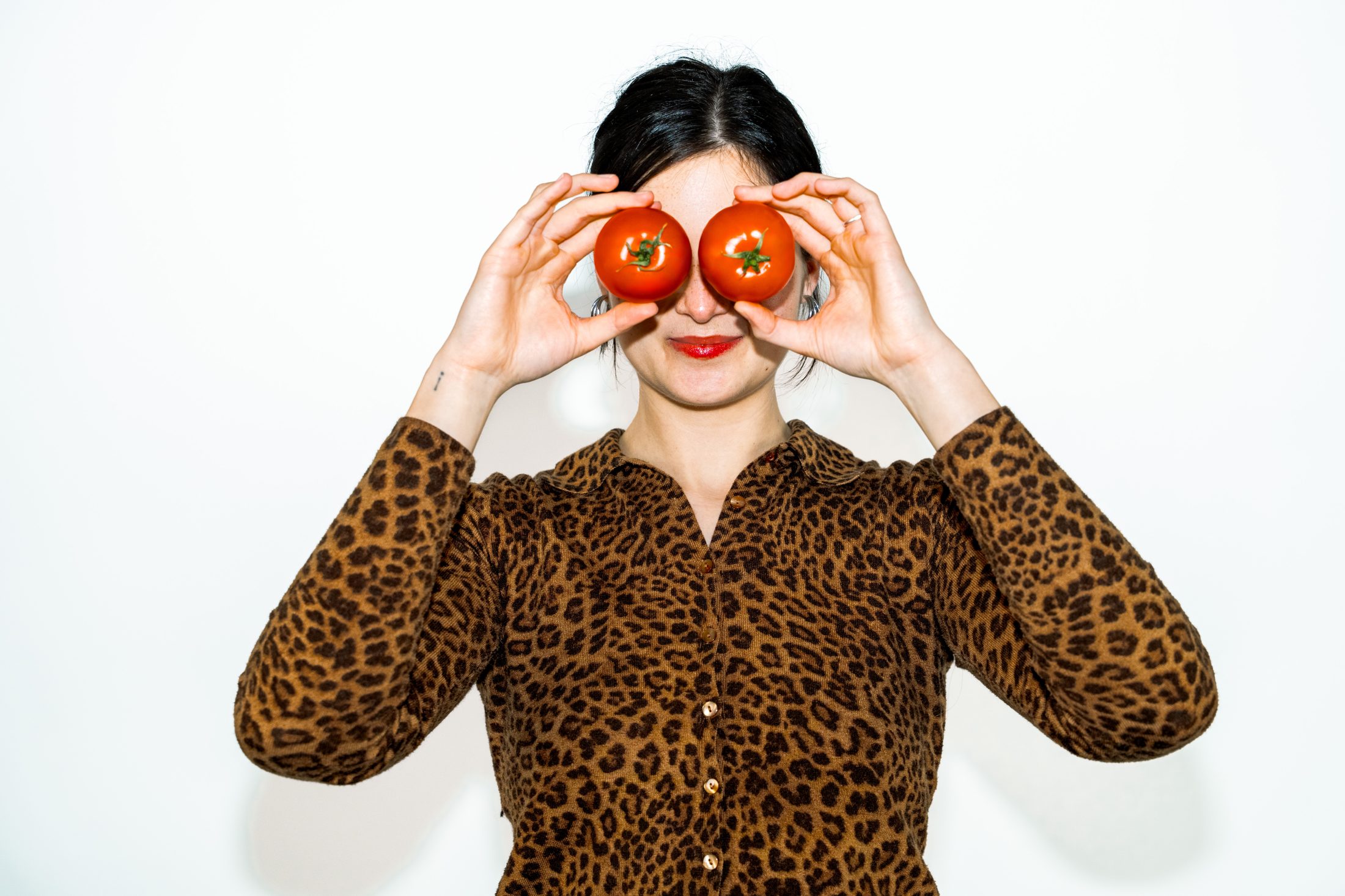 Kreative Social Media Kampagne mit Mutti: Eine Frau im Leoparden Look hält sich spielerisch zwei frische Tomaten vor die Augen. SR-STUDIOS. | SR-STUDIOS