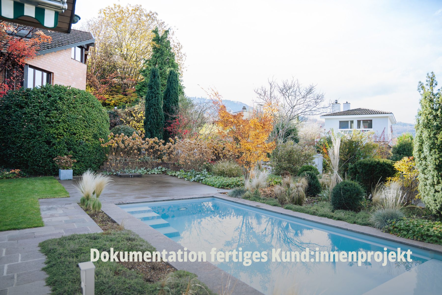 Premium Gartenfotografie als Referenzprojekt durch SR-STUDIOS: Ein luxuriöser Poolbereich in einer grosszügigen, harmonisch bepflanzten Gartenanlage unter klarem Himmel. Hochwertiger visueller Content für Vögtli Gartenbau GmbH. | SR-STUDIOS